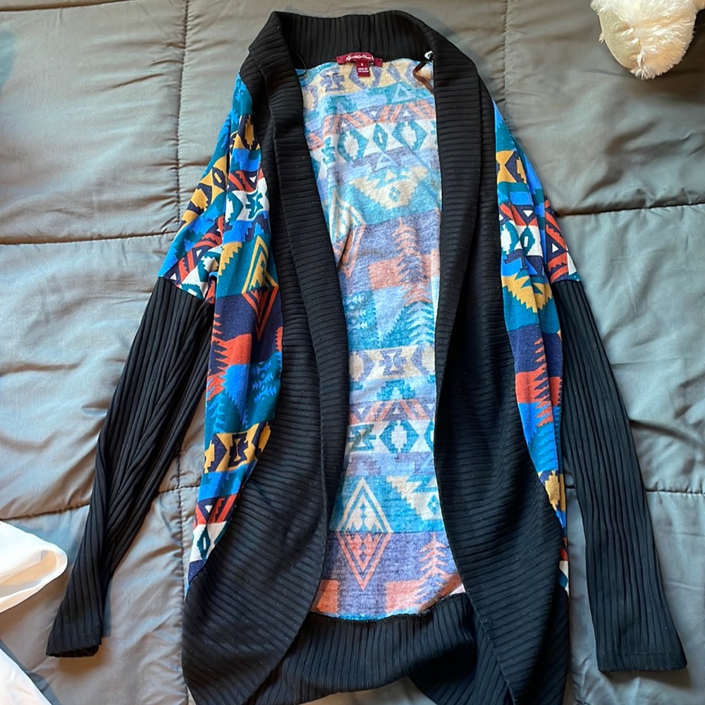 Black cardigan, blue red, burnt orange designs.